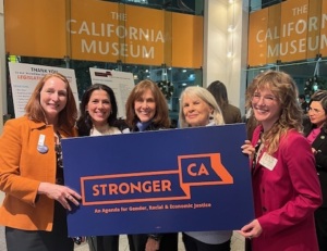 Four women in a group photo with the sign that reads"Stronger California".